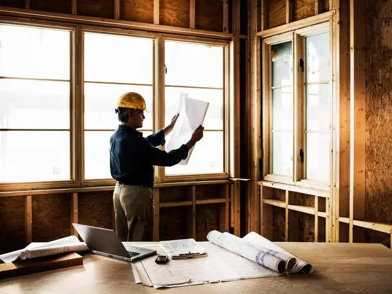 Builders Cromwell Contact Us - Architect reviewing blueprints indoors